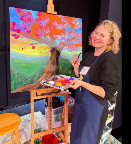 Lillian of Uplift Teams painting at an easel